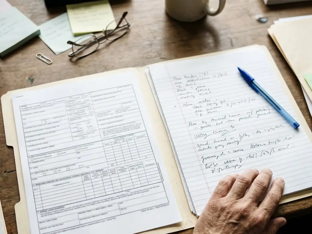 Claim paperwork reviewed alongside clinical notes at the desk